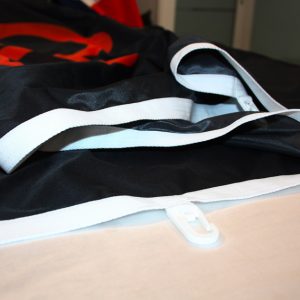 Bandiera personalizzata verticale - dettaglio tela di rinforzo bianca e moschettone in plastica.